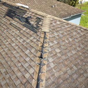 Damaged house roof with missing shingles after hurricane Ian in Florida. Consequences of natural disaster.