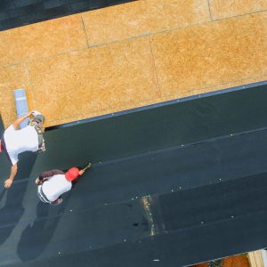 New asphalt bitumen shingles being installed on roof of residential building